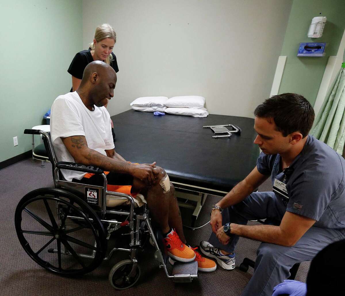 Quincy Davis works with physical therapist, Jorge Neira, and OTR student, Lindsay Eckert at the Quentin Mease Community Hospital, Friday, Aug. 12, 2016, in Houston. Davis and his family say that he was denied proper medical treatment during his two years in the Waller County Jail, where he was awaiting trial on charges for drugs and for assaulting police. After a month in two hospitals, he is now at this rehab hospital.
