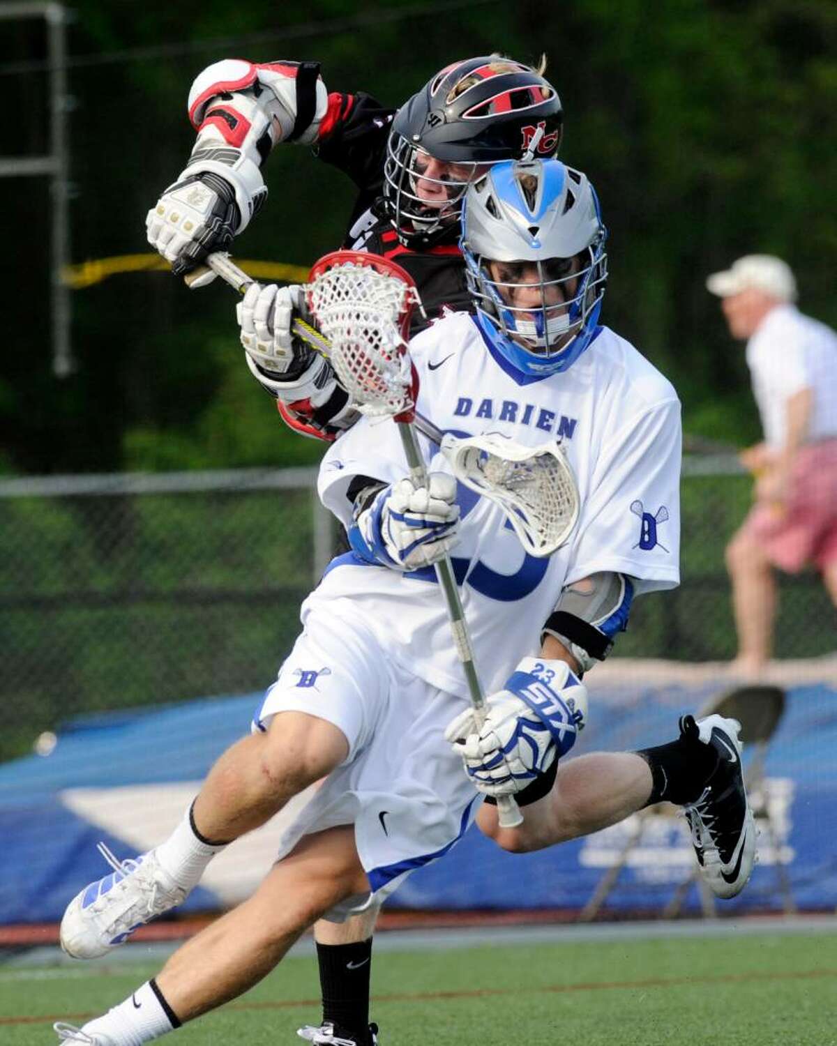Darien's Alden Frelinghuysen spins away from New Canaan's Todd Bratches as Darien High School hosts New Canaan High in a boys lacrosse game Saturday, May 1, 2010. Darien won 11-5.