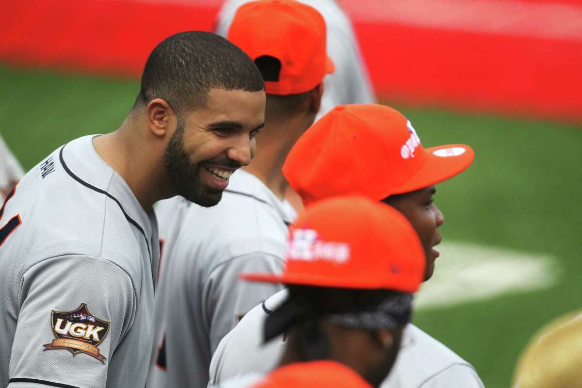 Drake, left, talks to his teammates during the Drake Celebrity Softball Game, Friday, May 22, 2015, in Houston.