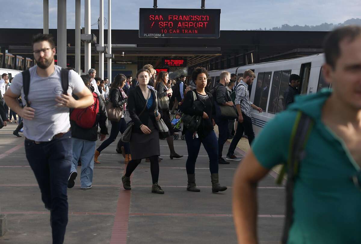 Passengers cross the platform to transfer to a San Francisco-bound train at the MacArthur BART station in Oakland, Calif. on Aug. 30, 2016.