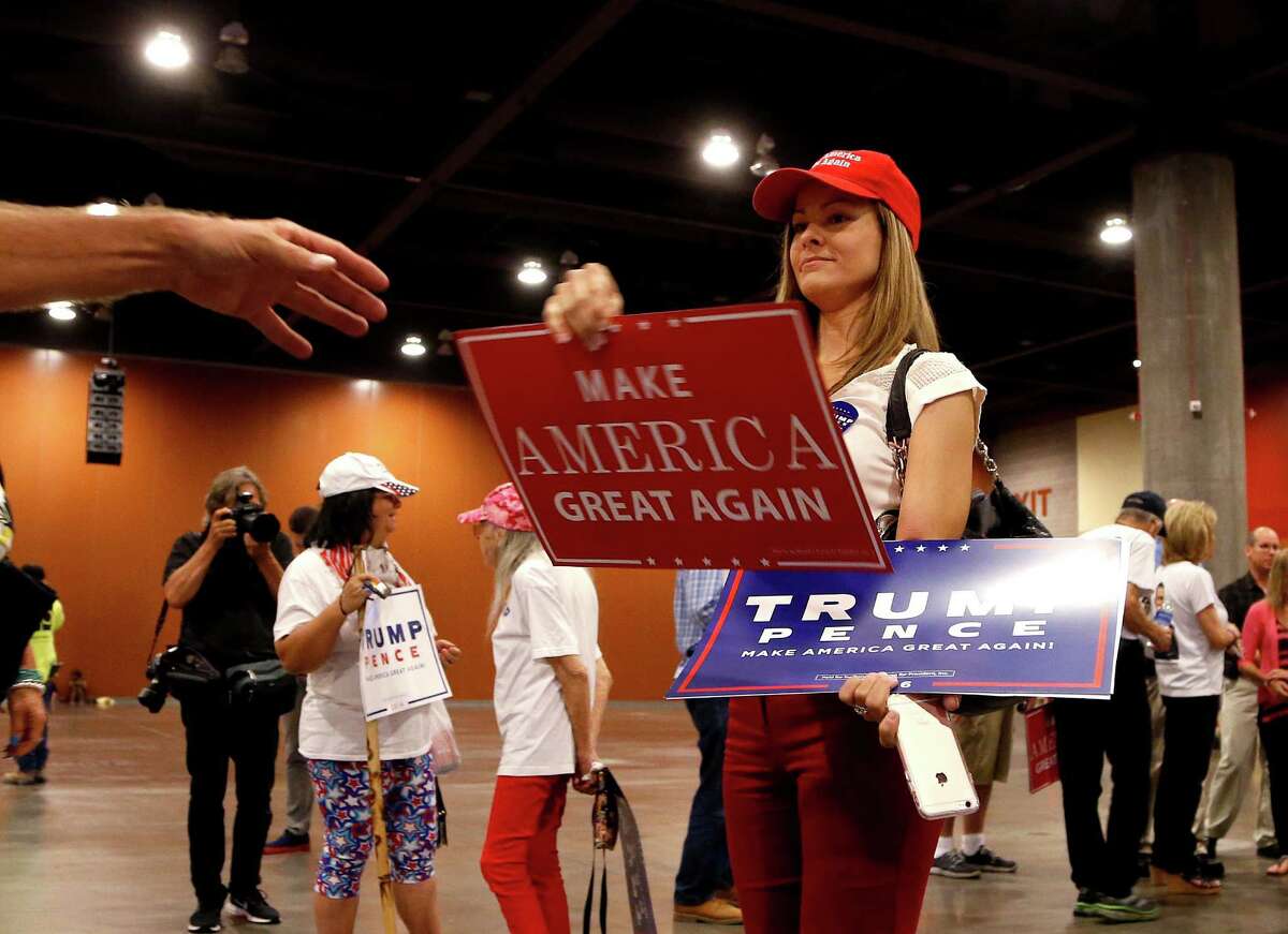 A supporter hands out campaign signs prior to Republican presidential candidate Donald Trump's speech during a campaign rally at the Phoenix Convention Center, Wednesday, Aug. 31, 2016, in Phoenix. (AP Photo/Ross D. Franklin)