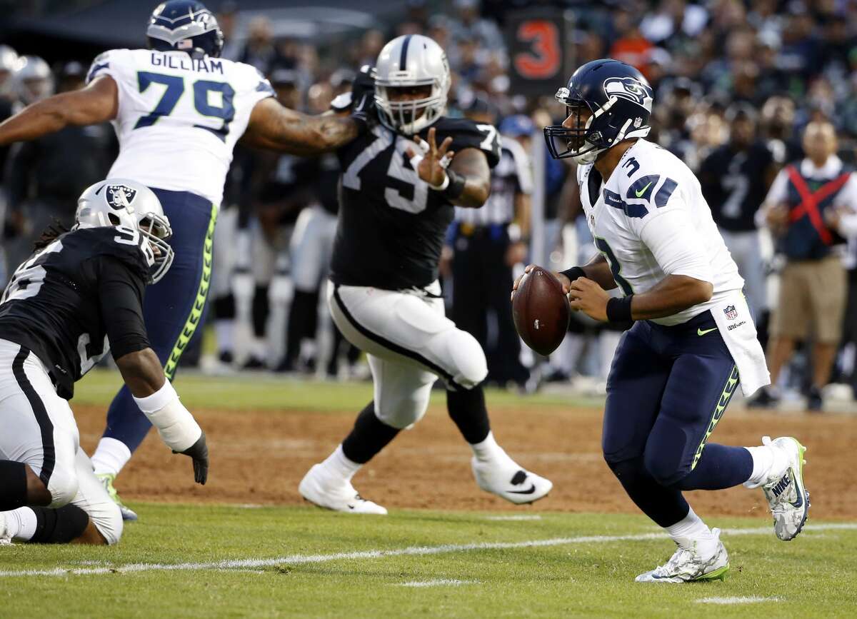 Seattle Seahawks quarterback Russell Wilson, right, runs out of the pocket against the Oakland Raiders during the first half of a preseason NFL football game Thursday, Sept. 1, 2016, in Oakland, Calif. (AP Photo/Tony Avelar)