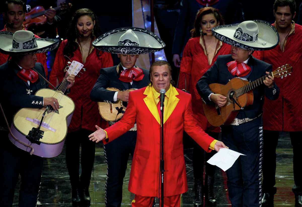 Mexican singer Juan Gabriel, front, performs during an event honoring Mexican comedian Roberto Gomez Bolanos, popularly known as Chespirito, at the National Auditorium in Mexico City. He died Aug. 28 in Santa Monica, California.