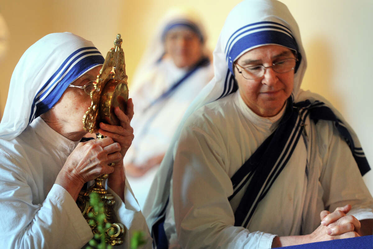 Sister Seton, left, and Sister Sarah, Missionaries of Charity from Bridgeport, pray with a relic of Mother Teresa following a ceremony at the Knights of Columbus Museum, in New Haven, Conn. Sept. 2, 1016. Mother Teresa will be canonized Sunday.