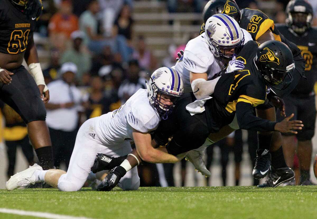 Montgomery linebacker Jacob Gallatin (32) and defensive tackle Keaton Bussell (28) tackle Aldine Eisenhower quarterback Robert Turner (14) during the second quarter of a non-district high school football game Friday, Sept. 2, 2016, at W.W. Thorne Stadium in Houston.