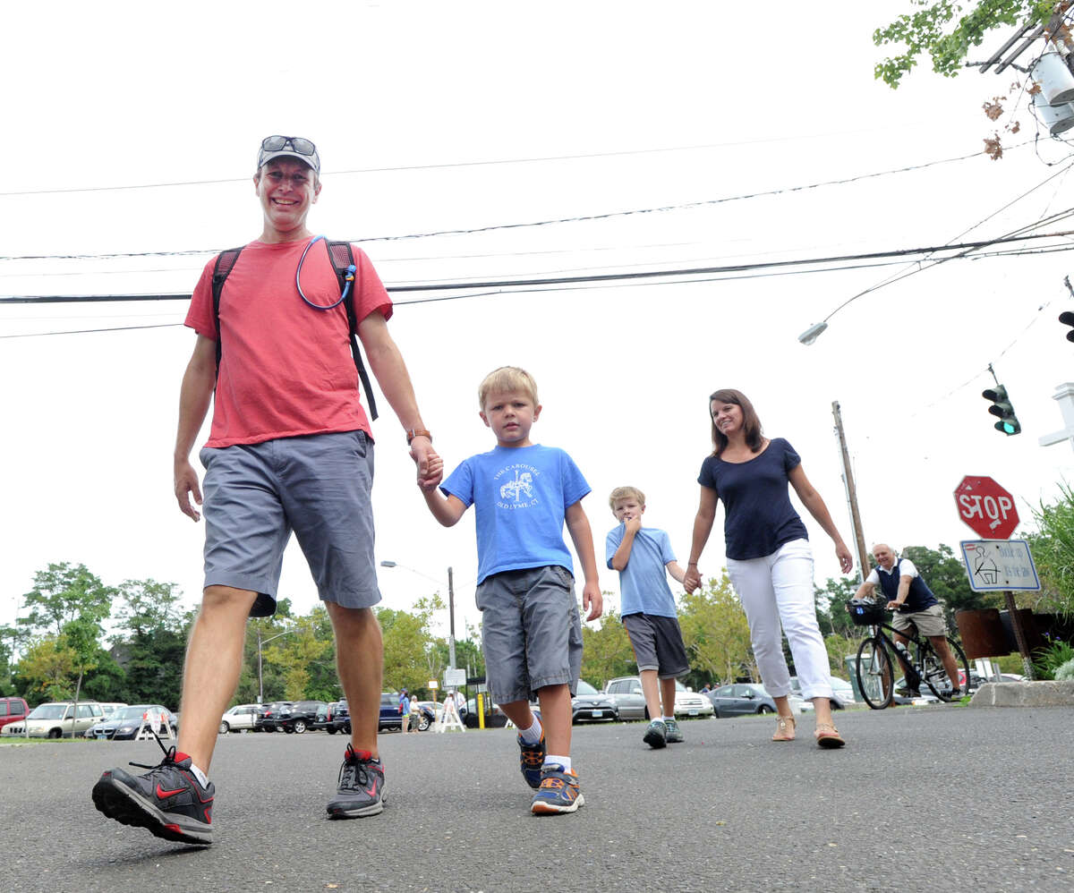 U.S. Senator Chris Murphy (D-Conn.), left, holds hands with his son Rider, 4, as Murphy's wife Cathy Holahan, right, holds hands with son Owen, 8, as they enter Roger Sherman Baldwin Park in Greenwich, Conn., Saturday morning, Sept. 3, 2016. Senator Murphy held a town meeting in the park that marked the end of a 130-mile walk across Connecticut to listen to and get feedback from state residents. Murphy was joined by his family on the Greenwich leg of his trek. Senator Murphy started his walk on Monday in Voluntown, Conn., on the Rhode Island border.