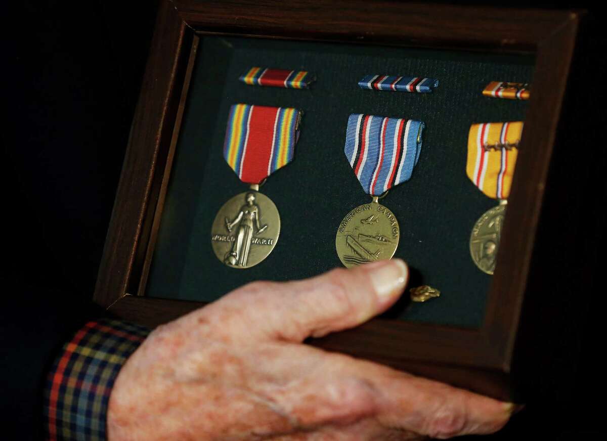 Donald D. Stinson, a U.S. Army Air Forces major who served in the Pacific during World War II holds the medals presented to him by Rep. Joaquin Castro on Saturday, Sept. 3, 2016. The medals are: the World War II Victory medal (from left), the American Campaign medal, the Asian Pacific Campaign medal along with the Philippine Liberation with Bronze Star ribbon and the World War II Honorable Discharge lapel pin. The sixth medal was Army Commendation medal (not shown). The medals were presented to Stinson in front of family at his home as a U.S. flag and other memorabilia from Stinson's days in the military served as a background for the ceremony. Now 93, Stinson joined the Army Air Forces on Oct. 6, 1942 and attended basic training in San Antonio. He later served in the Pacific and flew transport planes, once surviving a Japanese Kamikaze attack while he and his crew slept underneath the wings of their aircraft. After his military service, Stinson worked at San Antonio Independent School District as cafeteria director from 1968 to 1990. (Kin Man Hui/San Antonio Express-News)
