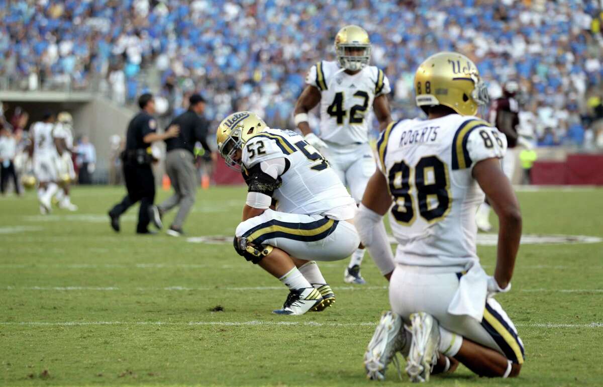 UCLA's Scott Quessenberry (52) and Takkarist McKinley (98) react after the team failed to score on fourth down in overtime against Texas A&M during an NCAA college football game Saturday, Sept. 3, 2016, in College Station, Texas. Texas A&M won 31-24 in overtime. (AP Photo/Sam Craft)