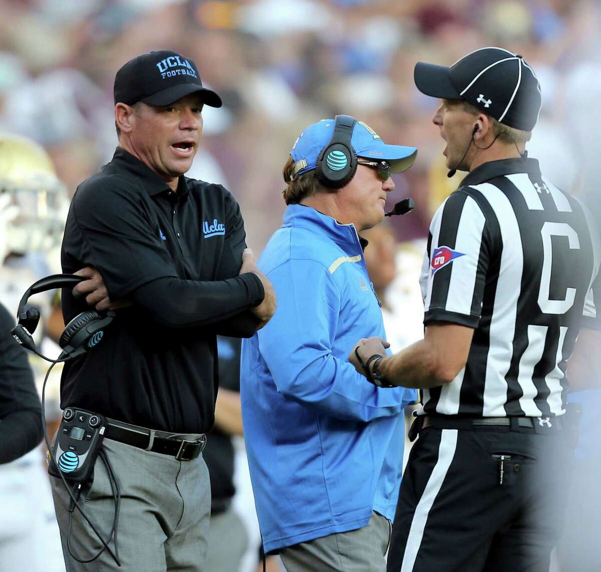 UCLA coach Jim Mora discusses a call with an official during overtime of an NCAA college football game against Texas A&M on Saturday, Sept. 3, 2016, in College Station, Texas. Texas A&M won 31-24. (AP Photo/Sam Craft)