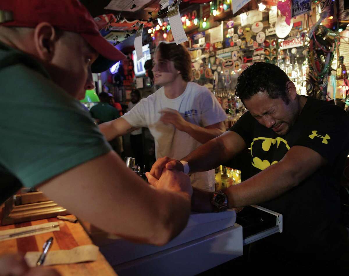 Bartender Mario Morales gets encouragement from patrons as he starts closing tabs after last call at Kay's Lounge, the oldest bar in Houston on Sunday, Sept. 4, 2016. Morales had been working at the bar for 14 years. "These people, the regulars, the people who clean, they are all my family," said Morales.