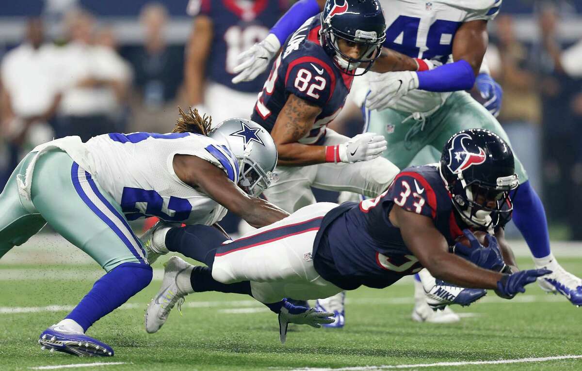 Texans running back Akeem Hunt (33) dives past Cowboys defensive back Dax Swanson (28) in the preseason finale. Hunt had two touchdowns in the victory.
