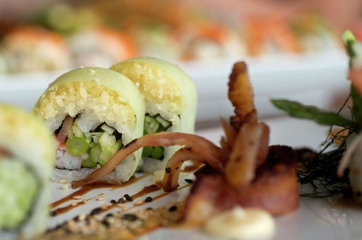 The sexy bacon roll, made of hickory smoked bacon, cucumber, asparagus, crab stick, tempura crunch in soy paper served with fantasy sauce, eel sauce and a creamy garlic sauce and shredded nori, is one of the signature rolls offered at Maru Sushi and Grill.