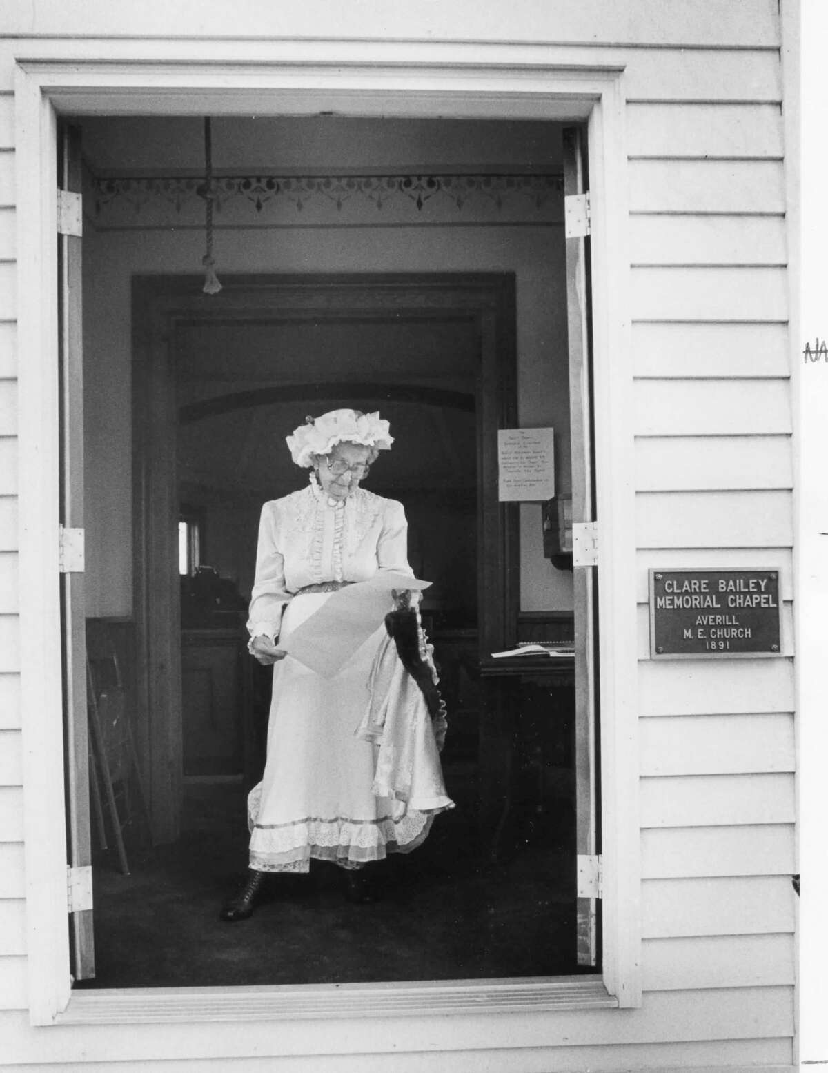 Dressed in costume from the past, Gertrude Bailey scans a history of the Averill Methodist Church before posting it at the Sanford Museum. The 1891 church structure was donated to the museum by Bailey in memory of her husband, Clare Bailey. September 1987