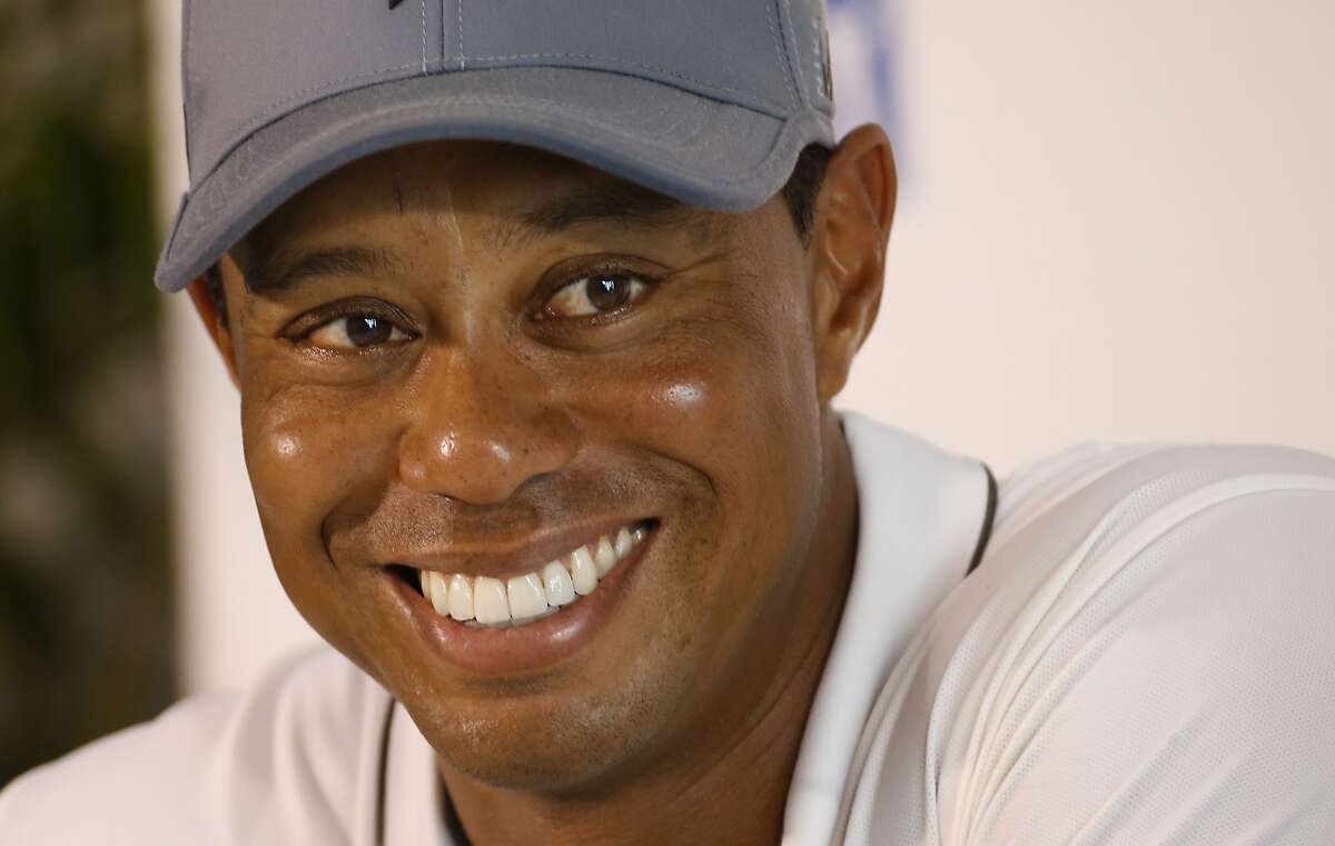 FILE - In this July 28, 2015, file photo, Tiger Woods smiles as he answers a question during a news conference prior to the start of the Quicken Loans National golf tournament, in Gainesville, Va. Tiger Woods says he hopes to play next month in the PGA's Safeway Open in Napa, California, his first competitive golf since August 2015. (AP Photo/Steve Helber, File)