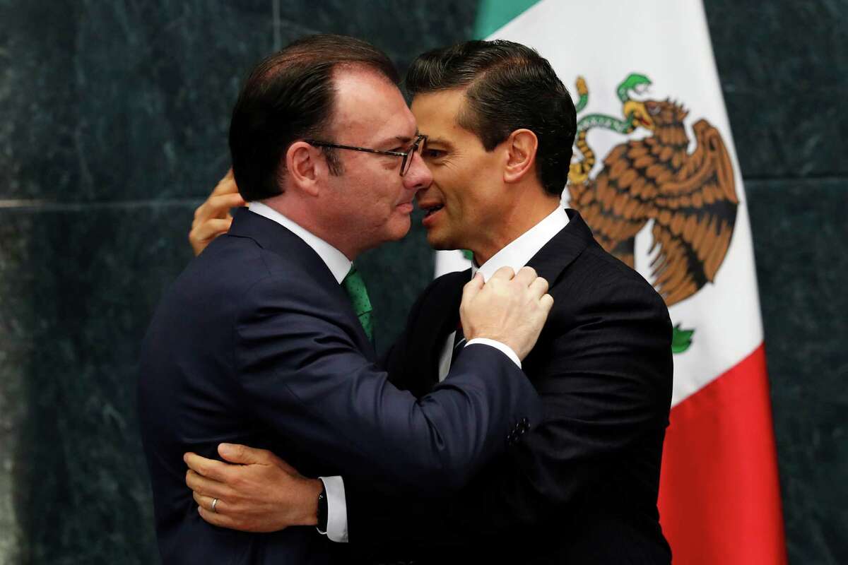 Mexico's President Enrique Pena Nieto, right, embraces Finance Secretary Luis Videgaray after accepting Videgaray's resignation at the presidential residence of Los Pinos in Mexico City, Wednesday, Sept. 7, 2016. The Treasury Ministry gave no reason for the resignation, but it came in the wake of Pena Nieto's widely criticized meeting with Republican presidential nominee Donald Trump in the Mexican capital last week. (AP Photo/Dario Lopez-Mills)