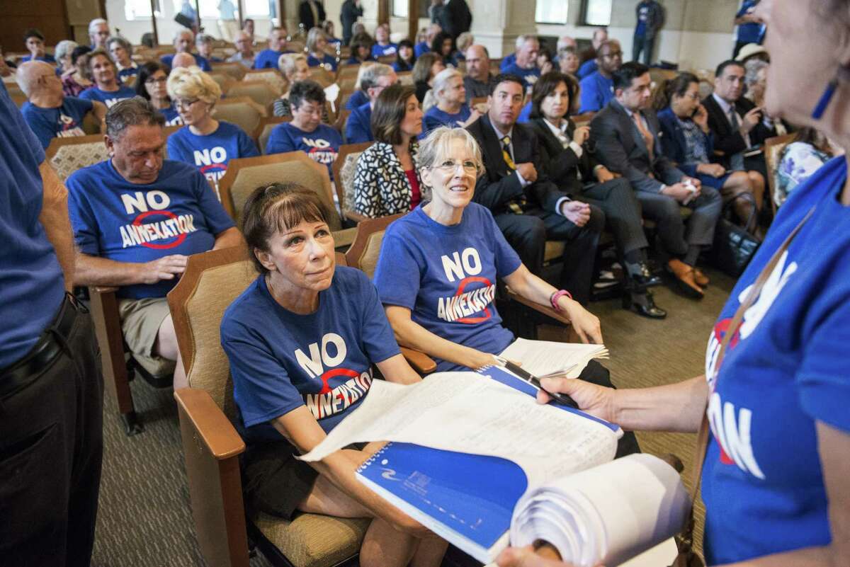 Sisters Kimberly Vogel, left, and Susan Vogel, right, wearing "No Annexation" t-shirts, sit in the front row during a San Antonio City Council meeting where they voted on whether to annex several parts of unincorporated Bexar County, notable a 15-square mile area along Interstate 10 West, on Thursday, September 8, 2016 in San Antonio, Texas.
