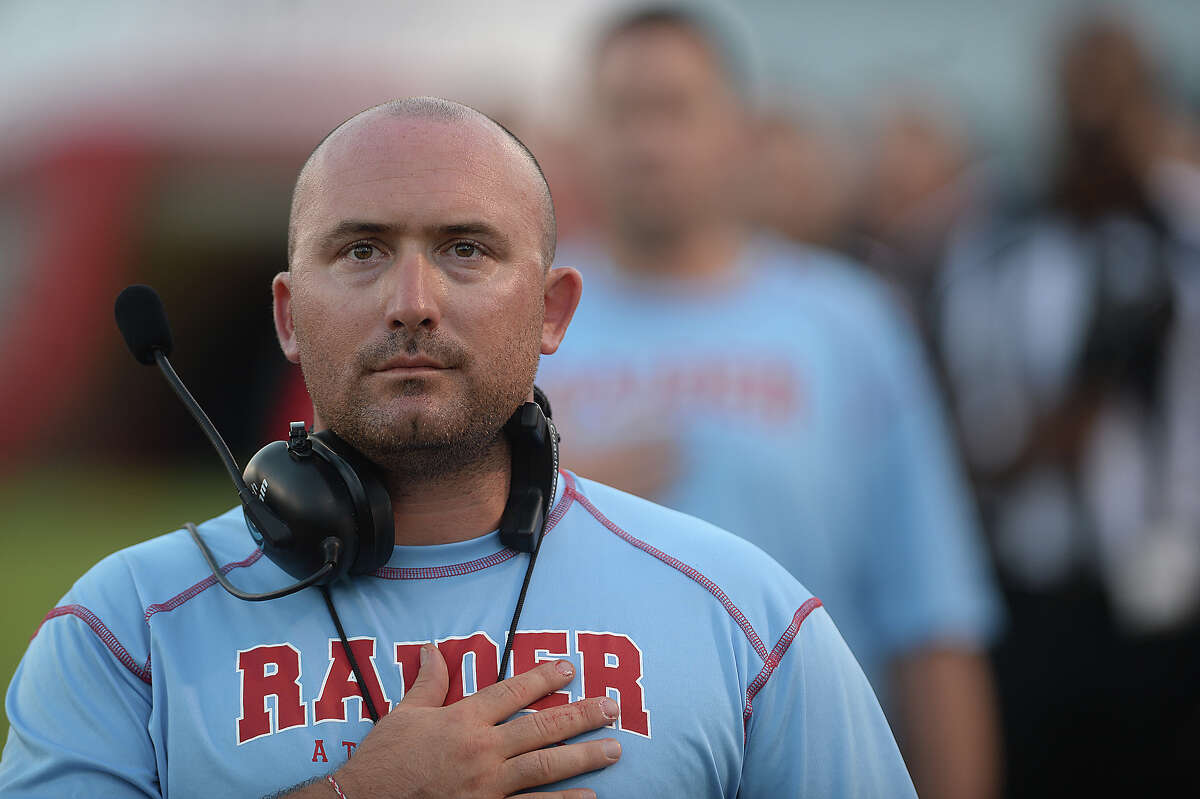 Lumberton's head coach Chris Babin joins in observing the National Anthem before they face Ozen during their district match-up Friday night in Lumberton. Photo taken Friday, September 25, 2015 Photo by Kim Brent