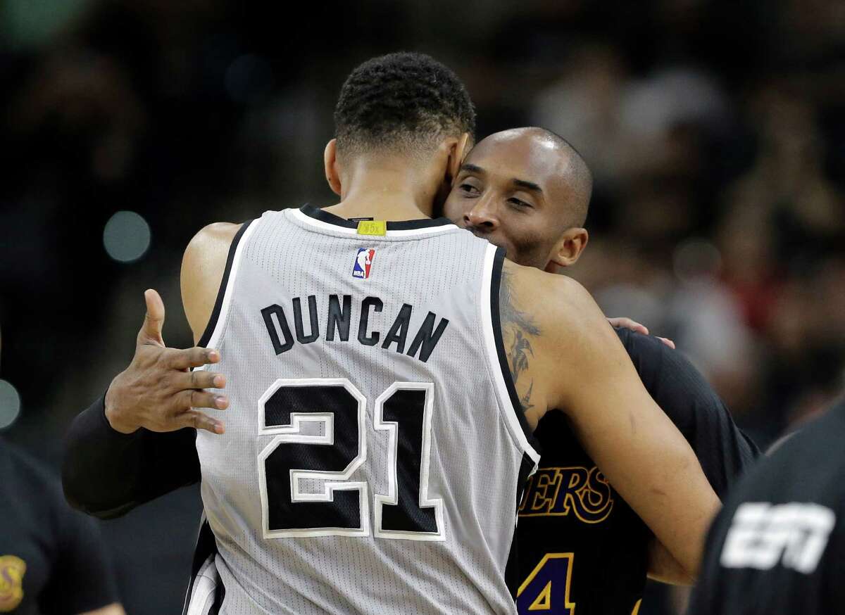 Spurs center Tim Duncan (21) hugs Los Angeles Lakers forward Kobe Bryant (24) prior to a game in San Antonio on Dec. 11, 2015. Duncan joined Kobe Bryant in retirement, ending a two-decade chapter of NBA history. Their exits, just like their games and personalities, couldn’t have been much different. But the destination is the same, as two of the greats of the sport will be Hall of Famers together in five years.