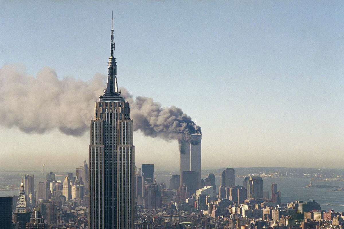 The twin towers of the World Trade Center burn on Sept. 11, 2001 behind the Empire State Building in New York after terrorists crashed two planes into the towers causing both to collapse.