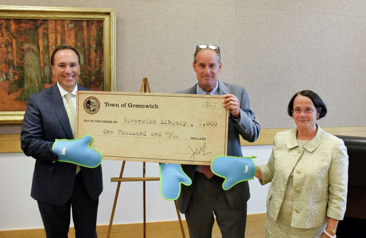 From left, First Selectman Peter Tesei, Greenwich Library Director Barabara Ormerod-Glynn and library Board of Trustees President Chip Haslun show off oven mitts that will be given as gifts to anyone contributing $100 or more to the library?’s annual fund.