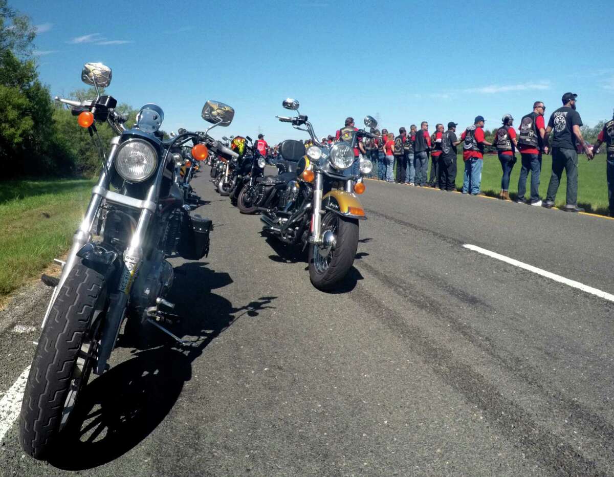 Motorcyclists hold hands at the site where Victoria Robles, 19, died with two others in a car accident on Tuesday. The bikers conducted a memorial motorcycle ride to the site with Victoria's parents, Pastors Jimmy and Annette Robles of Last Chance Ministries on Saturday, Sept. 10, 2016.