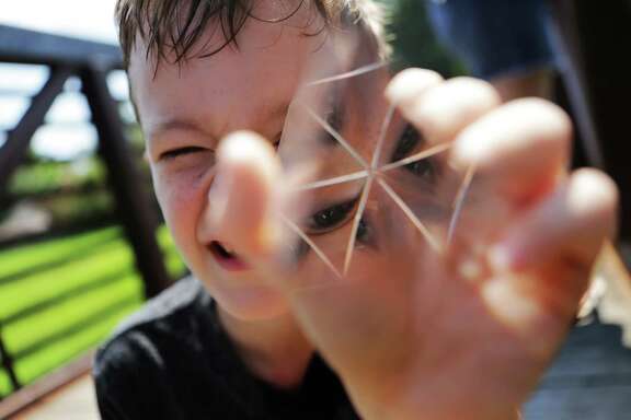 Roanin Walker's gaze disperses through the forms of a prism in face of the light. Walker finds comfort in science, maths and facts. He is a homeschooled by his mother after been denied special education. Friday, Sept. 2, 2016, in Kingwood. ( Marie D. De Jesus / Houston Chronicle )