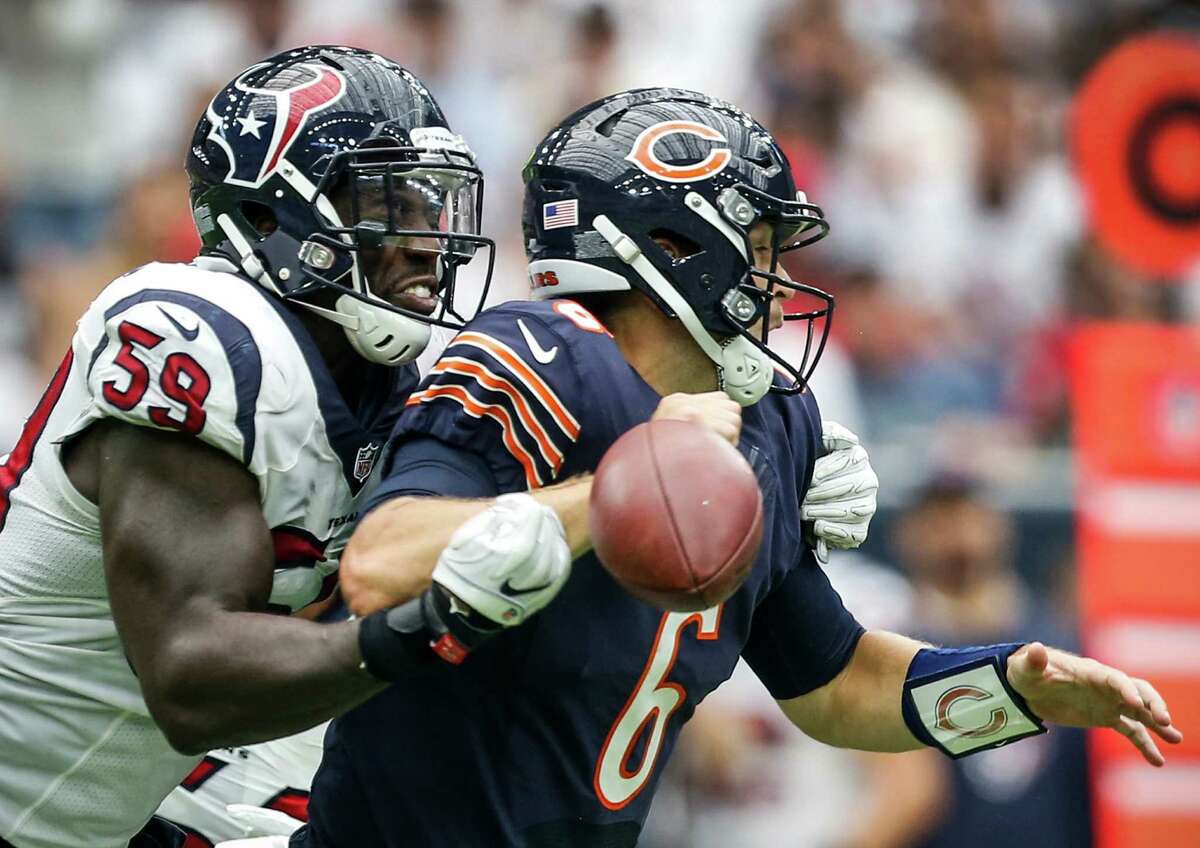 Bears quarterback Jay Cutler, right, loses the football as he is hit by Texans outside linebacker Whitney Mercilus. It was one of 13 times Cutler was hit Sunday afternoon.