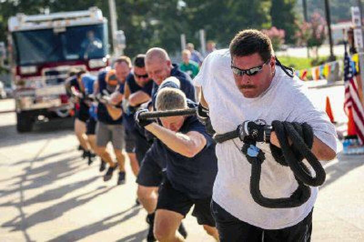 Firefighter Chris Mitcham, of The Woodlands Fire Department, leads a team of fellow firefighters in the fire truck pull event benefiting the Special Olympics Texas on Saturday at Armstrong Elementary School in Conroe.