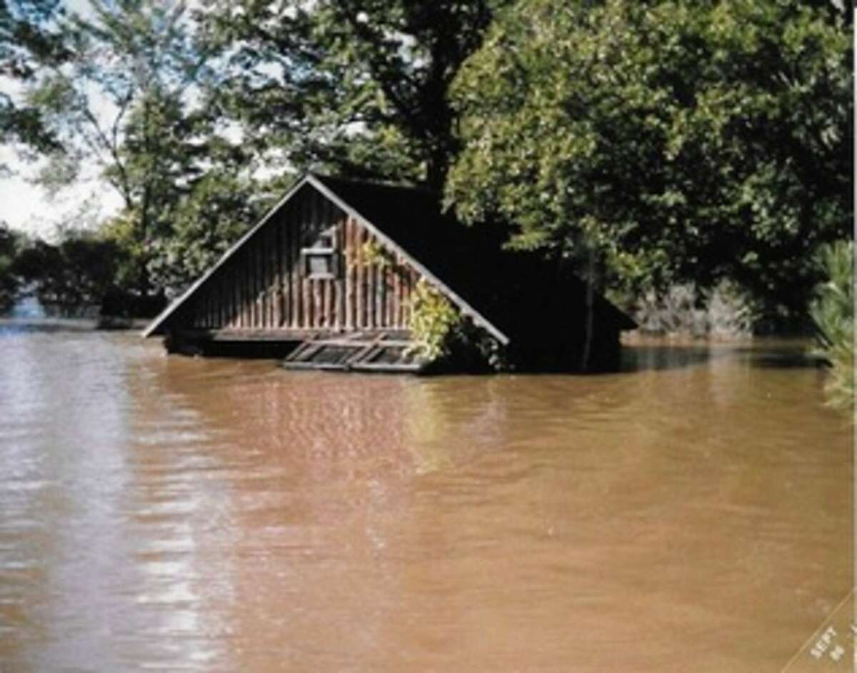 A log cabin is shown in 1986 surrounded by water on Pomranky Road. Photo courtesy of Kara (Pomranky) Malkowski of Midland