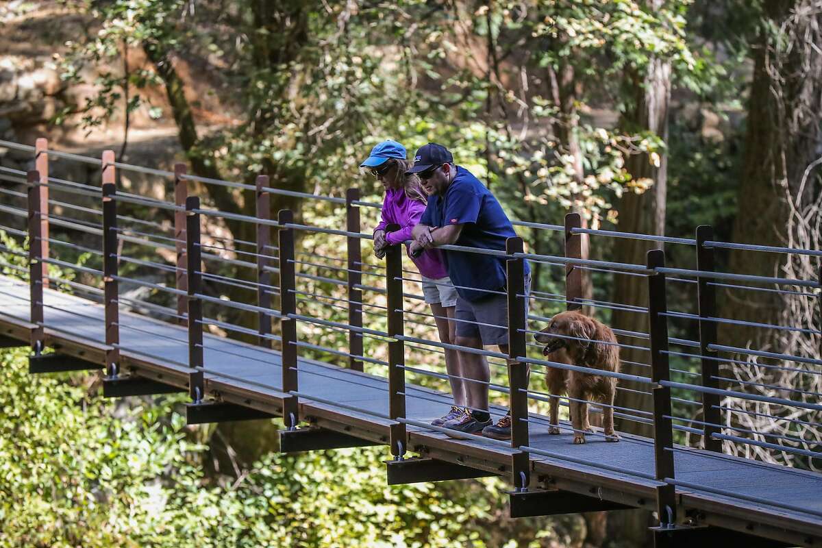 (l-r) Nancy Reese and Richard Strohl looks down at Deer Creek as they stand on a new suspension bridge, on the Deer Creek Tribute Trail in Nevada City, California, on Sunday, Sept. 4, 2016.
