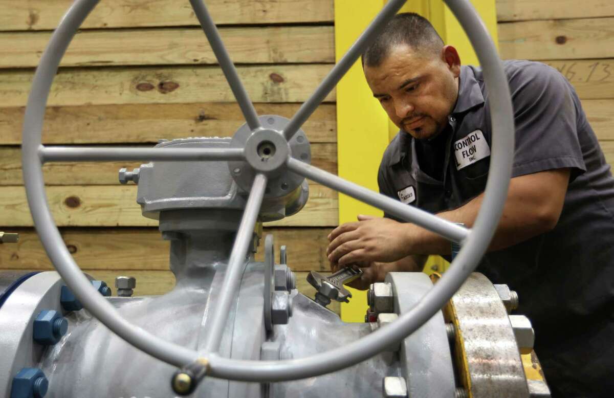 A worker tests an oil well head at Control Flow Inc. in Houston. The state's manufacturers generate nearly 15 percent of Texas' total economic output and employ more than 866,000 men and women in jobs that pay an average of nearly $80,000 a year, according to the Texas Association of Manufacturers and the Texas Association of Business. (Chronicle file photo)