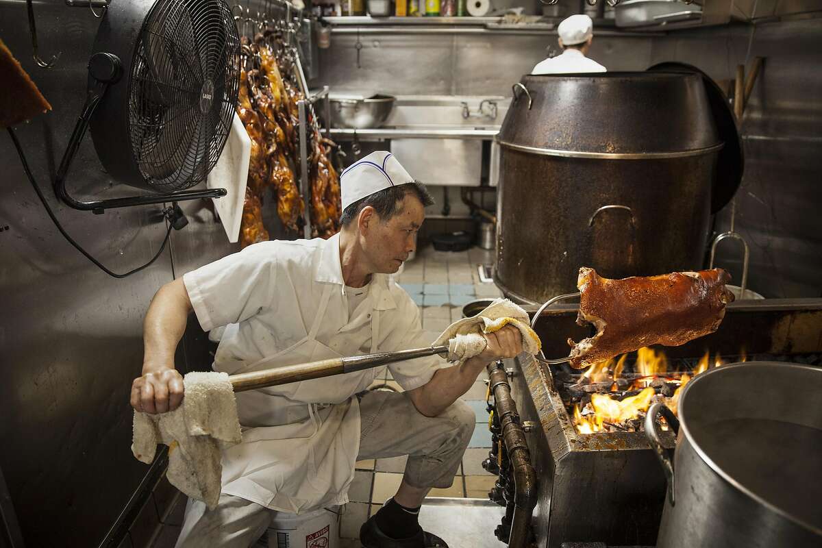 Master B.B.Q. chef Kow Kee Ng hand roasting pig over an open fire Peony Seafood Restaurant in Oakland, California, USA 10 Sep 2016. (Peter DaSilva/Special to The Chronicle)