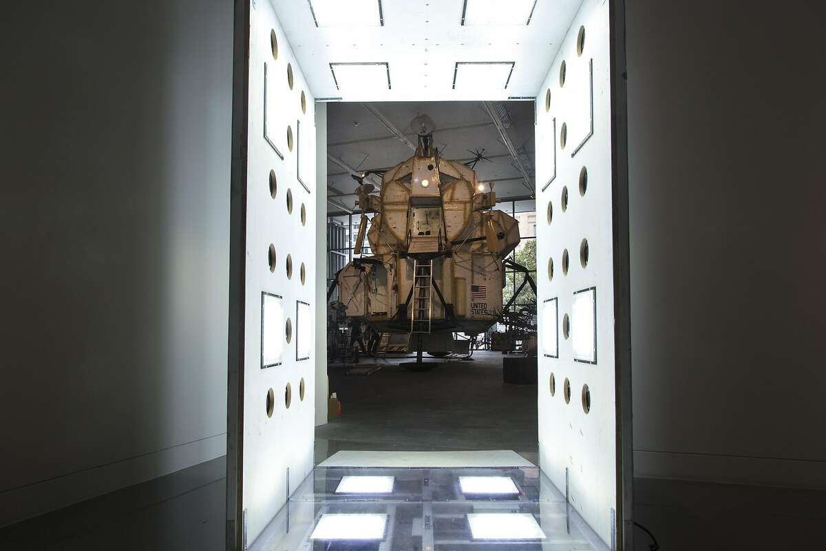 The 23-foot-tall "Landing Excursion Module (LEM)" (2007-2016) is seen in the background through "RISCAR: Robert Irwin Scrim Clean Air Room" (2012), by Tom Sachs, during "Space Program: Europa," an exhibition at the Yerba Buena Center for the Arts on Monday, Sept. 12, 2016 in San Francisco, Calif.