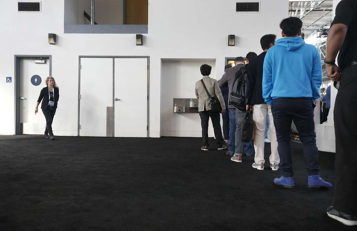 Men attending the TechCrunch Disrupt conference stand in a long line to use the restroom while there's no waiting for the women's room (left) in San Francisco, Calif. on Tuesday, Sept. 13, 2016.
