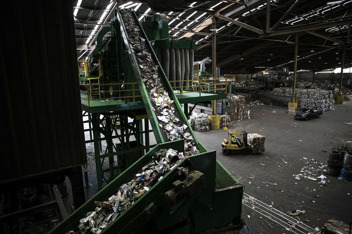 Recyclable materials are seen traveling to a sorting machine as a worker transfers a finished bundle with a forklift at Recology's Recycle Central at Pier 96 in San Francisco, Calif. on Monday, Sept. 12, 2016.