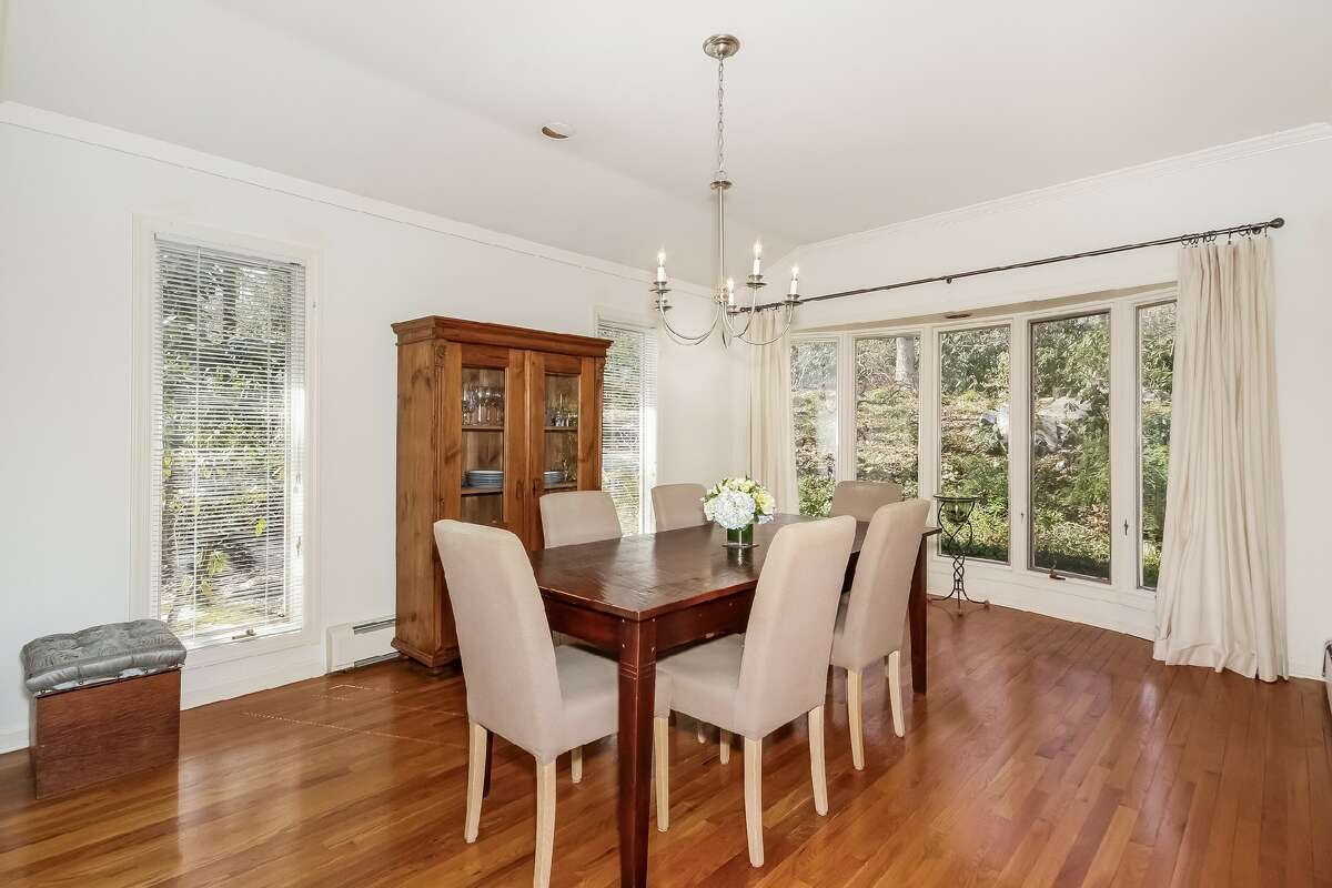 In the formal dining room there is a bay/bow window and a wall of nearly floor-to-ceiling casement windows that look over the pond and gardens.