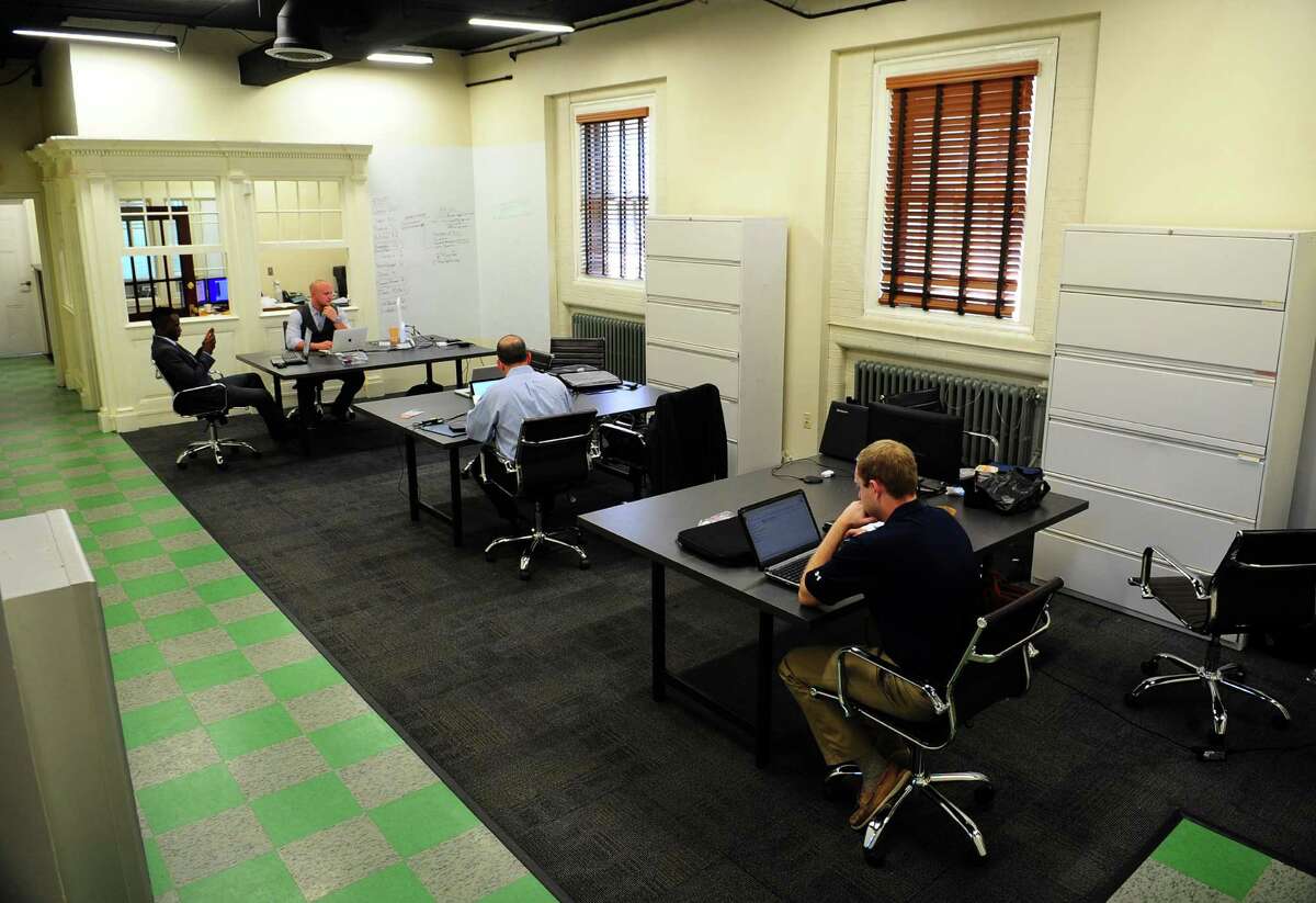 Members of the startup HelpGrowCT, which is trying to use artificial intelligence for a business advisor role, are at work inside a converted firehouse at 135 Clarence St. in Bridgeport, Conn., on Wednesday Sept. 14, 2016.