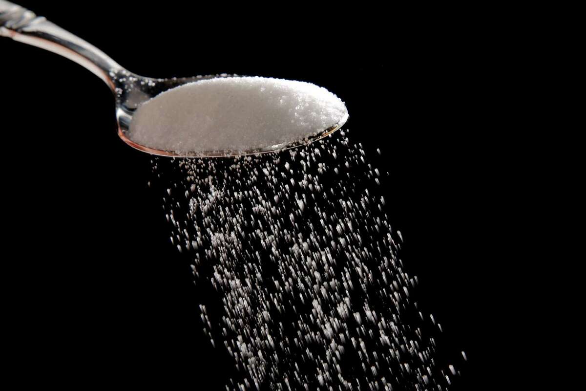 Granulated sugar is poured in Philadelphia, Monday, Sept. 12, 2016. A new study released Monday details how the sugar industry worked to downplay emerging science linking sugar and heart disease. It's the latest installment of an ongoing project by a former dentist to reveal the industry's decades-long attempt to influence science. The Sugar Association said it questions the author's attempt to play into current anti-sugar sentiment. (AP Photo/Matt Rourke)