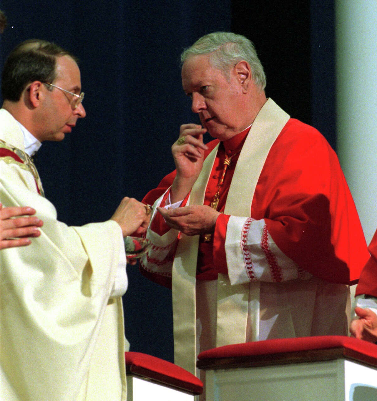 Cardinal Edward Michael Egan receives communion from his succesor Bishop William E. Lori during Lori's installation as the fourth Bishop of Bridgeport in 2001.