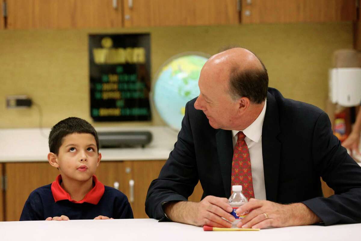 Johan Uvin, acting U.S. assistant secretary for career, technical and adult education, talks with Bowden Elemenatry School second-grader Brandon Garza-Roldan, 7, during a tour of the school.