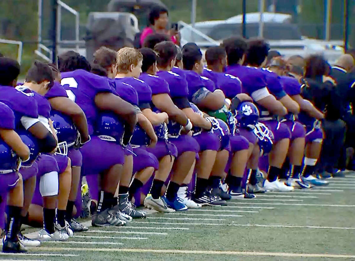 The Garfield High School football players take a knee during the national anthem before their game Friday, Sept. 16, 2016.