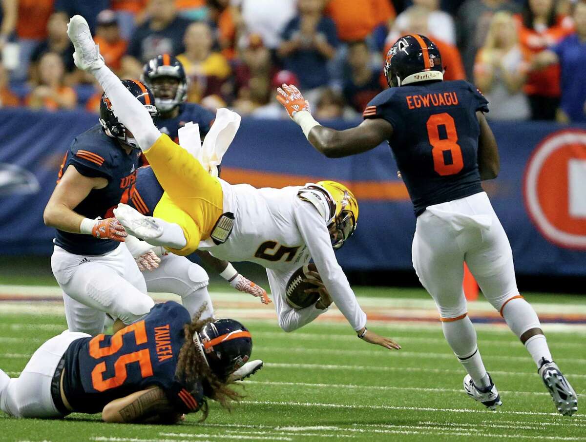 Arizona State Sun Devils quarterback Manny Wilkins flips after being hit by UTSA Roadrunners linebacker Josiah Tauaefa as UTSA Roadrunners safety Michael Egwuagu moves in on the play during second half action Friday Sept. 16, 2016 at the Alamodome. The Arizona State Sun Devils won 32-28.