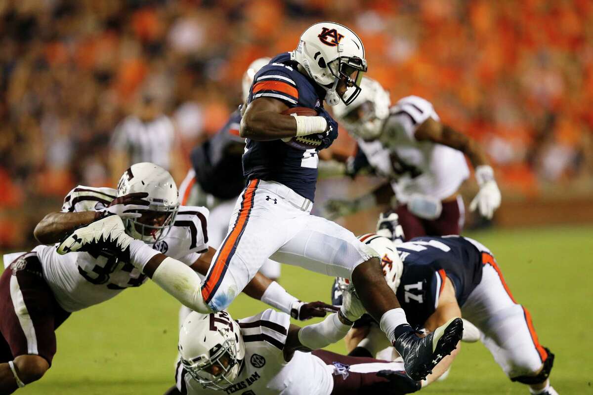 Auburn running back Kerryon Johnson leaps over Texas A&M defensive back Nick Harvey in the second half during an NCAA college football game, Saturday, Sept. 17, 2016, in Auburn, Ala. (AP Photo/Brynn Anderson)