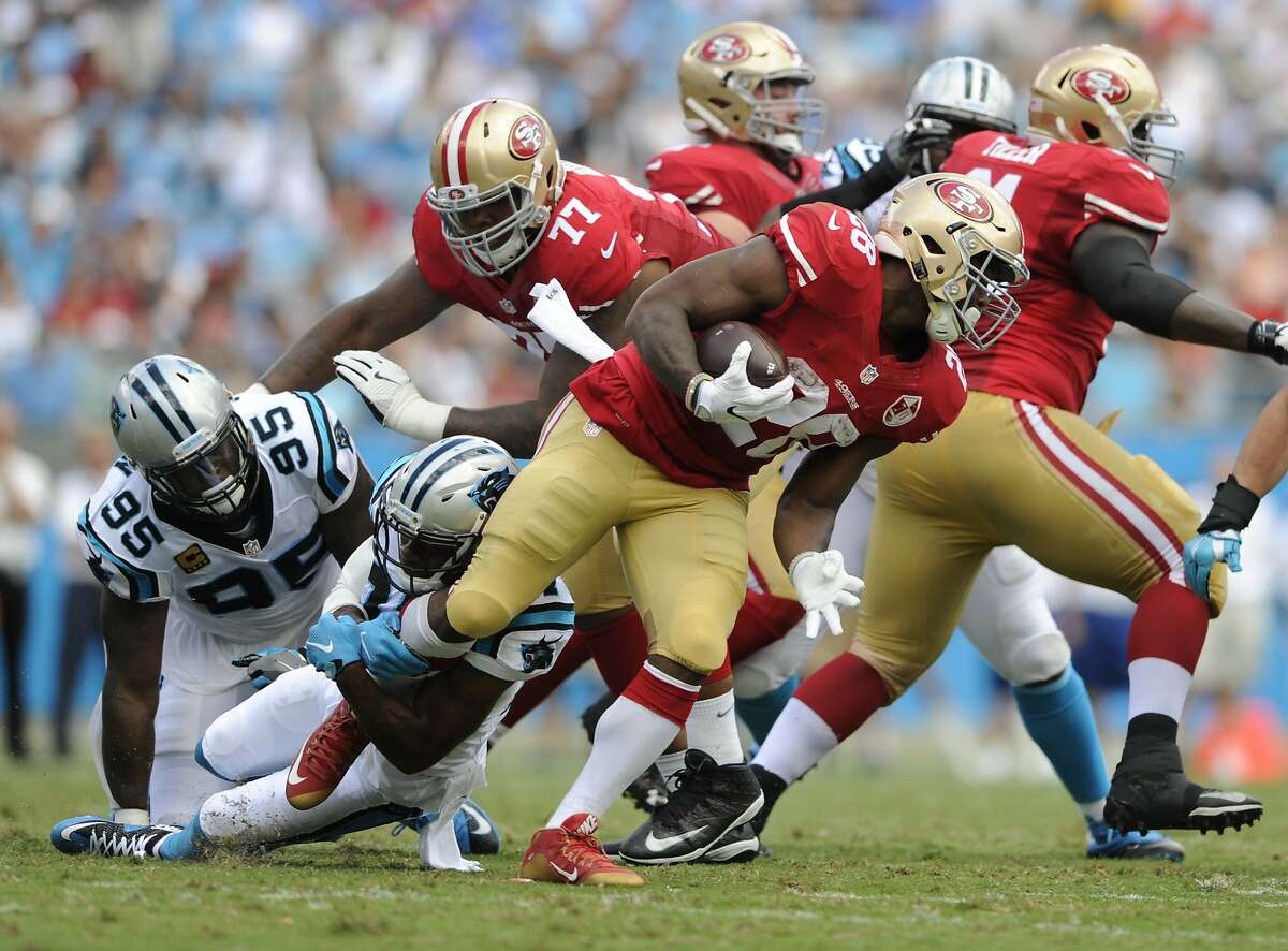 San Francisco 49ers' Carlos Hyde (28) tries to run through a Carolina Panthers tackle in the first half of an NFL football game in Charlotte, N.C., Sunday, Sept. 18, 2016. (AP Photo/Mike McCarn)