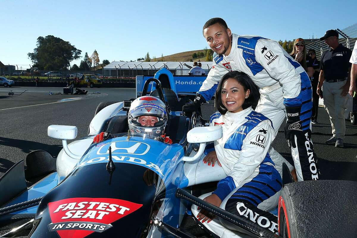 Grand Marshal for the GoPro Grand Prix of Sonoma Ayesha Curry and her husband Stephen Curry pose for a photo with Mario Andretti after taking a hot lap in a two-seater IndyCar at Sonoma Raceway on September 18, 2016 in Sonoma, California. (Photo by Lachlan Cunningham/Getty Images)