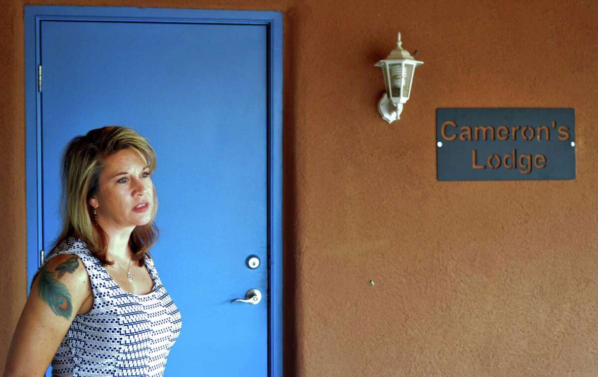 In this Aug. 9, 2016 photo, Jennifer Weiss-Burke, executive director of a youth recovery center in Albuquerque, N.M., stands by one of the rooms at the recovery center named after her son, Cameron Weiss. He died of a heroin overdose in 2011. Weiss-Burke said her teenage son's descent into drug addiction started with an opioid prescription a doctor wrote for him for a wrestling injury. (AP Photo/Mary Hudetz)