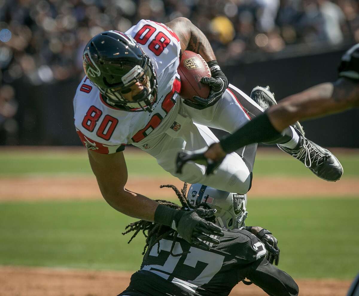 Reggie Nelson #27 of the Oakland Raiders upends Levine Toilolo #80 of the Atlanta Falcons at the Oakland-Alameda Coliseum in Oakland, Calif. on September 18th, 2016.