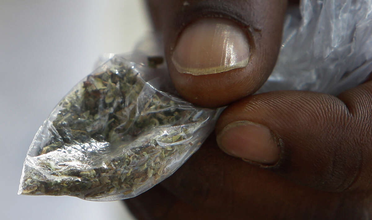 A man holds a man of Kush, also known as K2, that he bought for five dollars in a vacant lot near Peggy Park, a known drug gathering site, Wednesday, June 29, 2016, in Houston. K2 has been a problem for law enforcement with the public for years, and now has become a problem in prisons, too.