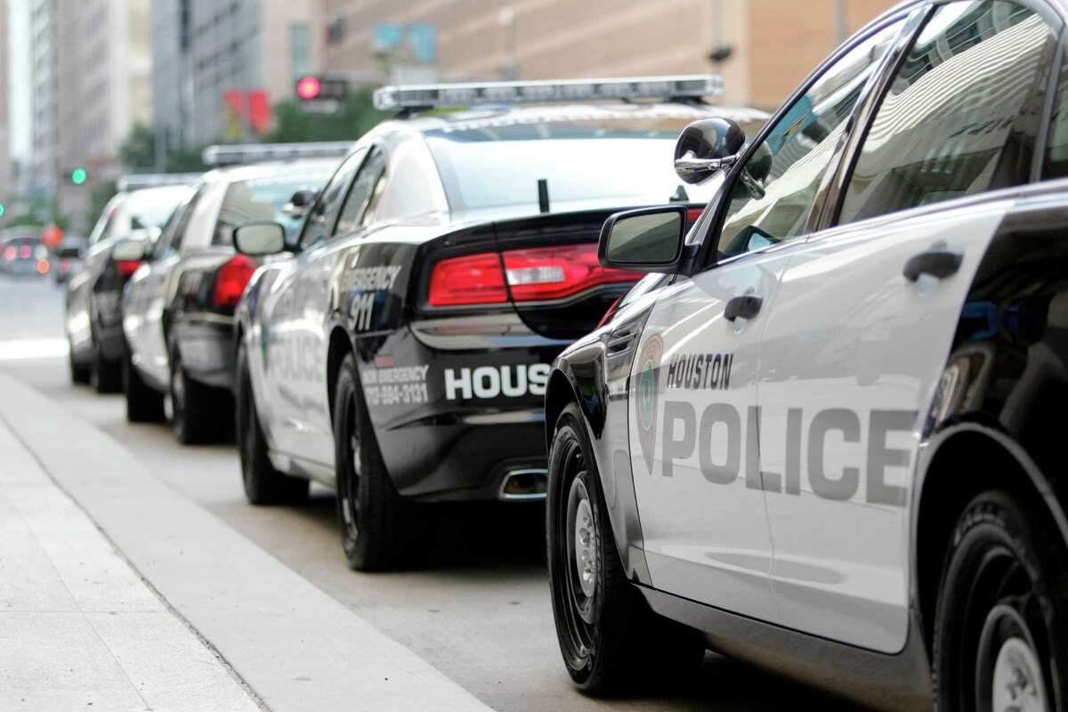 Houston Police Department patrol cars parked outside HPD's downtown headquarters. ﻿