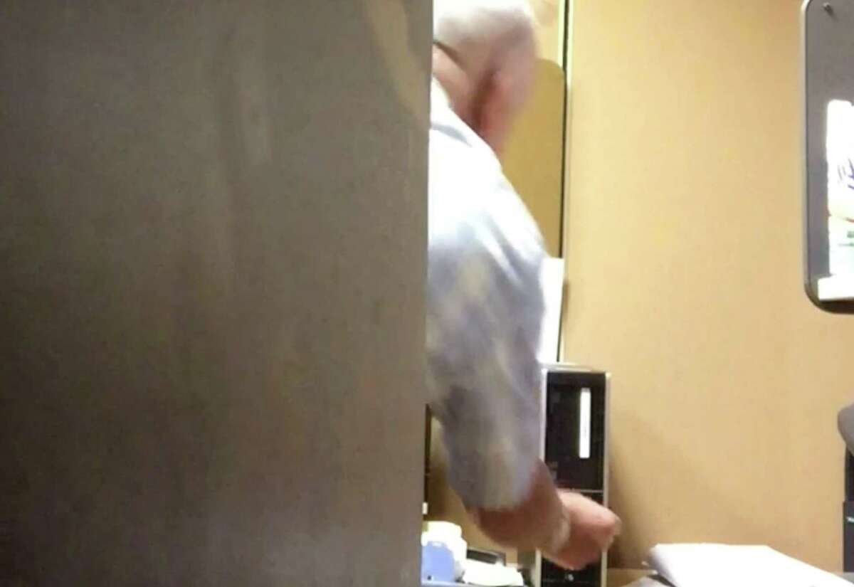 Still frame from surveillance video shot by Mark Karam who is suing the NY Power Authority, contending he was harassed at work. This is a shot of a co-worker allegedly turning off his computer.